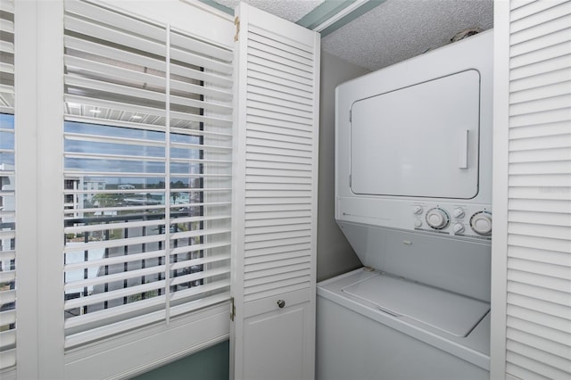 laundry area featuring stacked washer and clothes dryer and a textured ceiling