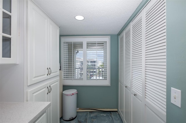 clothes washing area featuring a textured ceiling