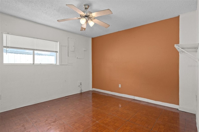 empty room featuring ceiling fan and a textured ceiling