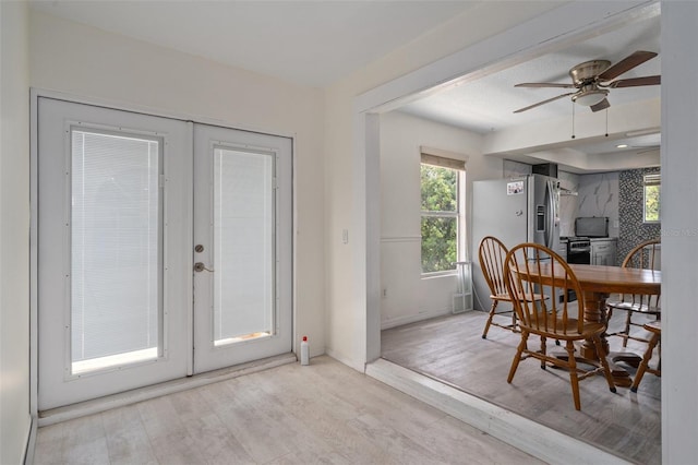 dining room with ceiling fan, light wood-type flooring, and french doors