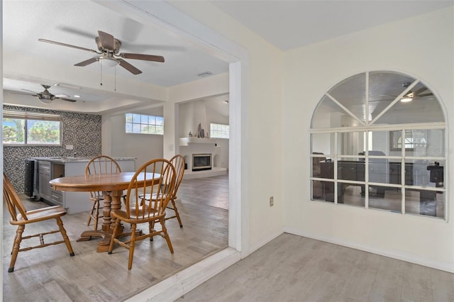 dining space featuring light wood-type flooring, plenty of natural light, and ceiling fan