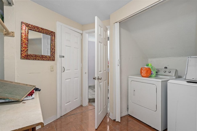 clothes washing area featuring washing machine and clothes dryer and light parquet floors