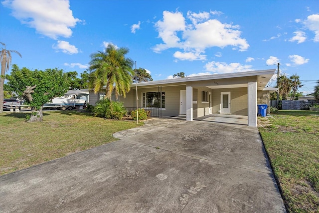 106 Aurora St E, Venice, FL 34285 - view of front of property with concrete block siding, an attached carport, a front yard, concrete driveway, and covered porch