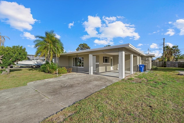 106 Aurora St E, Venice, FL 34285 - view of front of house with concrete driveway, fence, a front lawn, and an attached carport