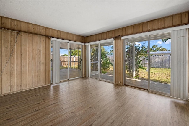 106 Aurora St E, Venice, FL 34285 - unfurnished room with wooden walls, plenty of natural light, and wood finished floors