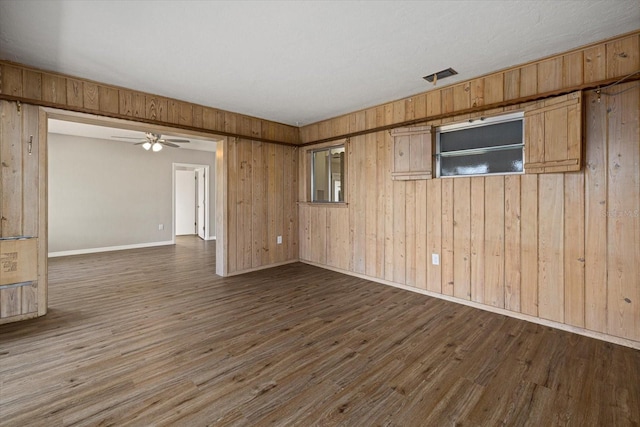106 Aurora St E, Venice, FL 34285 - unfurnished room featuring visible vents, wood finished floors, baseboards, ceiling fan, and wooden walls