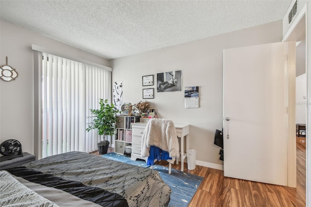 bedroom with wood-type flooring and a textured ceiling