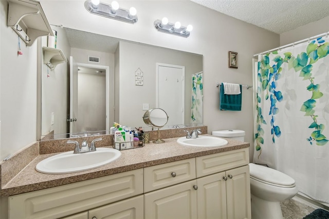 bathroom with vanity, a shower with shower curtain, a textured ceiling, and toilet