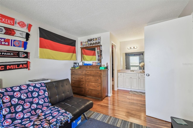 sitting room with hardwood / wood-style flooring and a textured ceiling