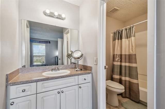 bathroom with vanity, toilet, a textured ceiling, and walk in shower