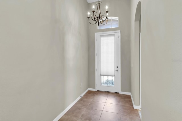 entryway featuring a notable chandelier, light tile patterned floors, and a high ceiling