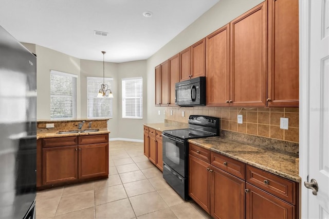 kitchen featuring light stone counters, black appliances, pendant lighting, a notable chandelier, and light tile patterned flooring