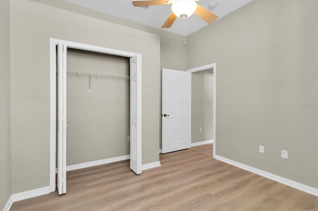 unfurnished bedroom featuring ceiling fan, a closet, and light wood-type flooring