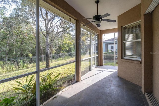 unfurnished sunroom with ceiling fan