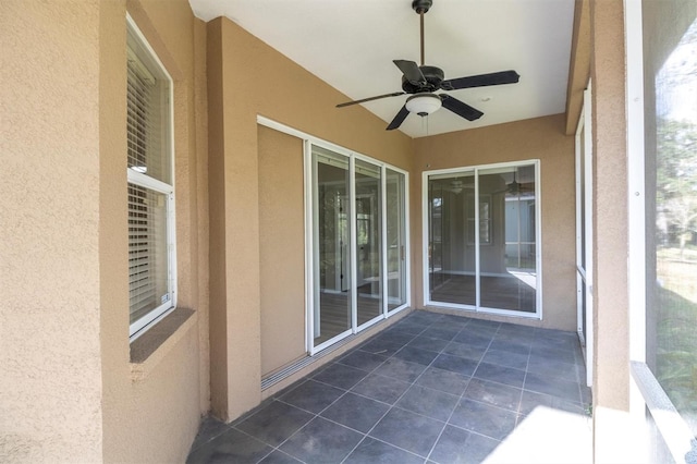 unfurnished sunroom featuring ceiling fan