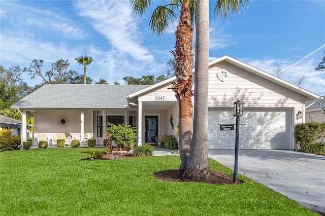 view of front of home with covered porch, a garage, and a front lawn