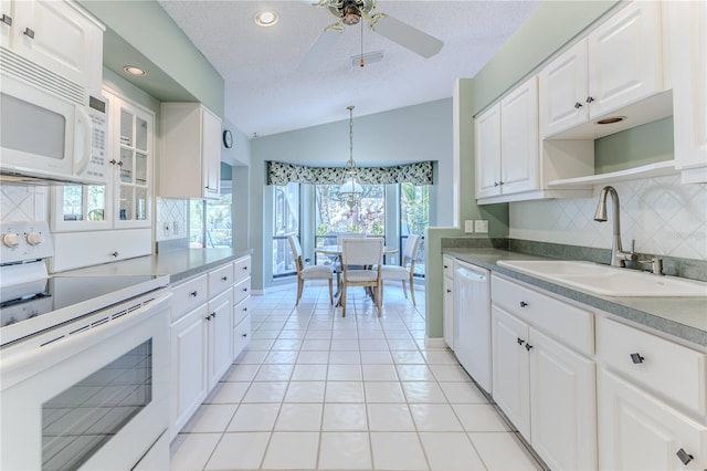 kitchen with lofted ceiling, white cabinetry, and white appliances