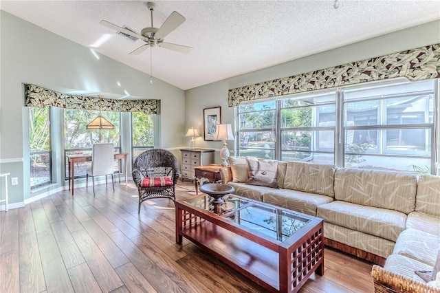 living room with a textured ceiling, ceiling fan, lofted ceiling, and hardwood / wood-style flooring