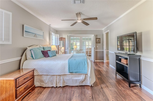 bedroom featuring ceiling fan, dark hardwood / wood-style flooring, ornamental molding, and a textured ceiling