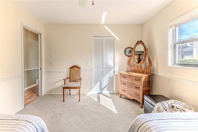 carpeted bedroom featuring ceiling fan and a closet