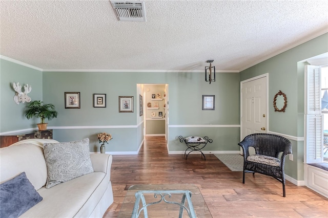 living room featuring a textured ceiling, hardwood / wood-style flooring, and crown molding