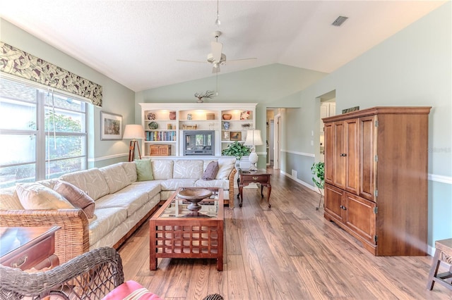 living room with ceiling fan, wood-type flooring, and vaulted ceiling