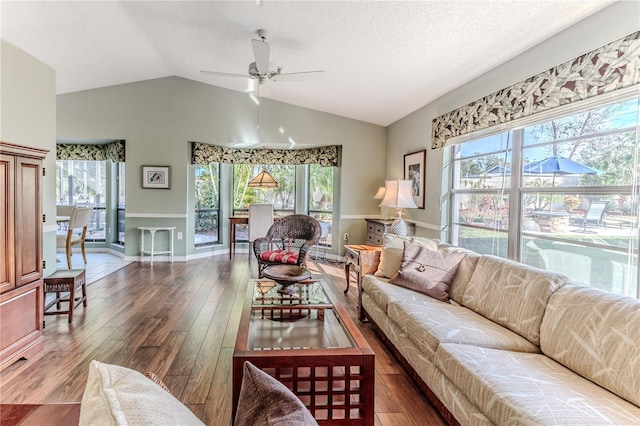 living room featuring a wealth of natural light, ceiling fan, and lofted ceiling