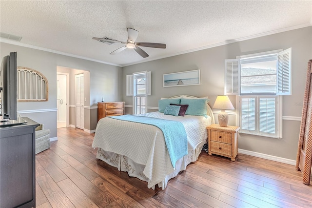 bedroom with hardwood / wood-style floors, ceiling fan, ornamental molding, and a textured ceiling