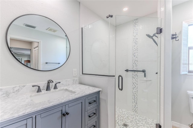 bathroom with vanity, toilet, and an enclosed shower