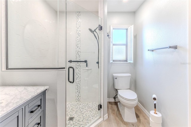 bathroom featuring hardwood / wood-style floors, vanity, toilet, and an enclosed shower