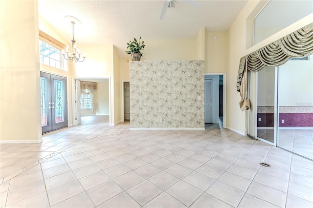 interior space featuring a notable chandelier, a towering ceiling, and french doors