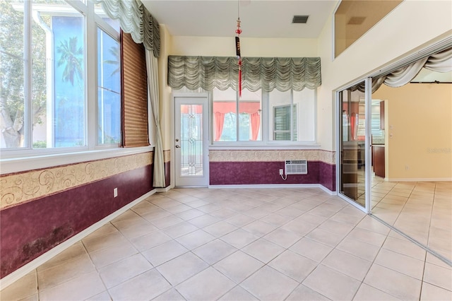 interior space featuring tile patterned flooring and an AC wall unit