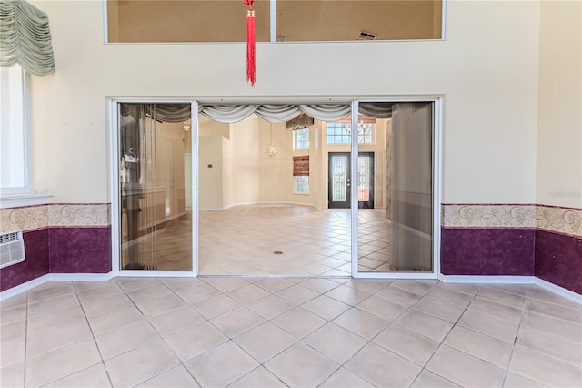 spare room featuring tile patterned flooring, an AC wall unit, and plenty of natural light