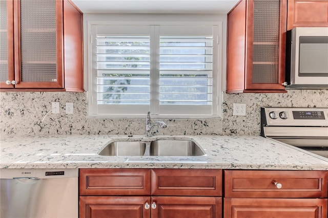 kitchen featuring decorative backsplash, sink, stainless steel appliances, and light stone counters