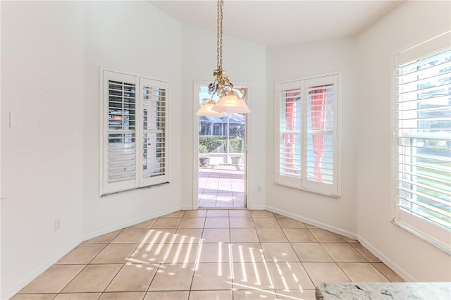 unfurnished dining area with a wealth of natural light, light tile patterned floors, and vaulted ceiling