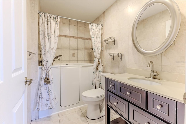 bathroom with tile patterned floors, vanity, tile walls, and toilet