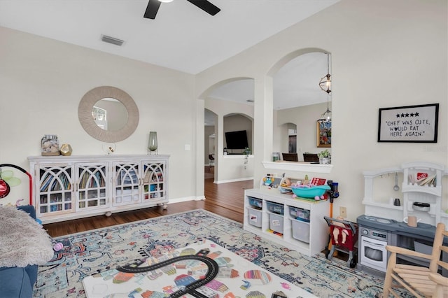 living room with dark hardwood / wood-style flooring and ceiling fan