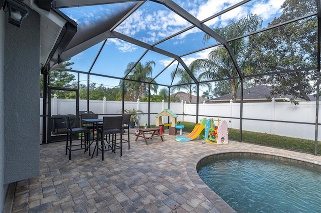 view of patio / terrace featuring a playground, glass enclosure, and a fenced in pool