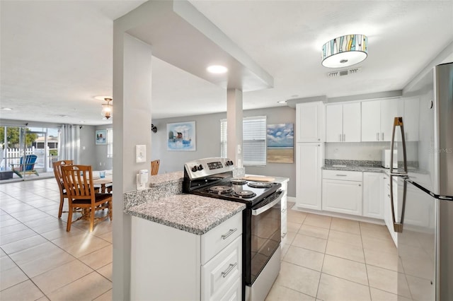 kitchen with light stone countertops, white cabinetry, light tile patterned floors, and stainless steel appliances