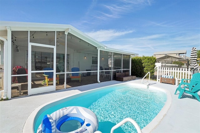 view of swimming pool featuring a patio area and a sunroom