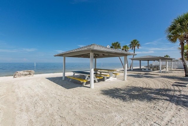 view of property's community with a beach view, a gazebo, and a water view