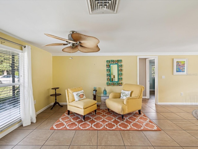 living area with ceiling fan, light tile patterned floors, and ornamental molding