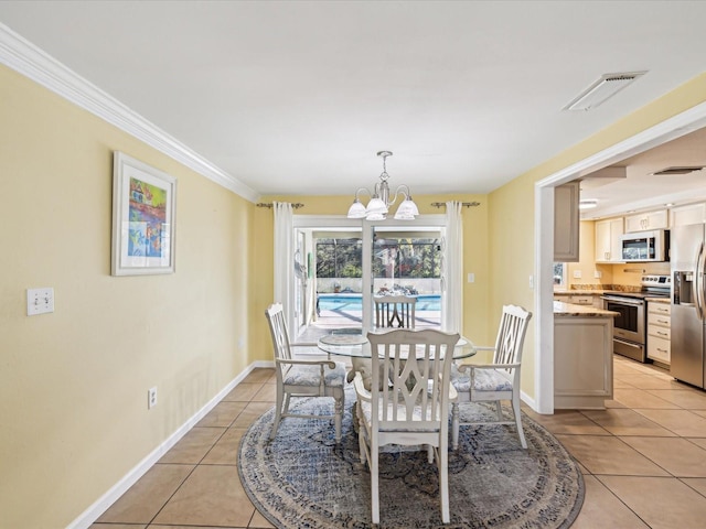 tiled dining room with a chandelier and crown molding