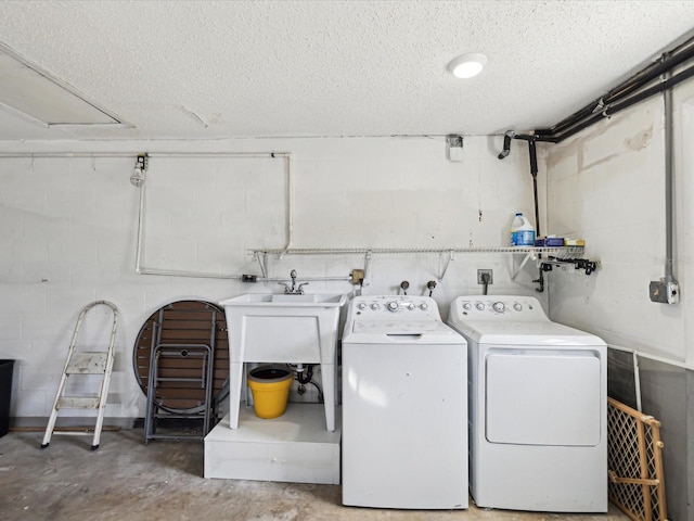 clothes washing area featuring washer and dryer and a textured ceiling