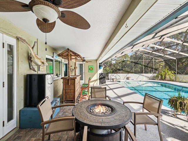 view of patio / terrace with french doors, glass enclosure, and an outdoor fire pit