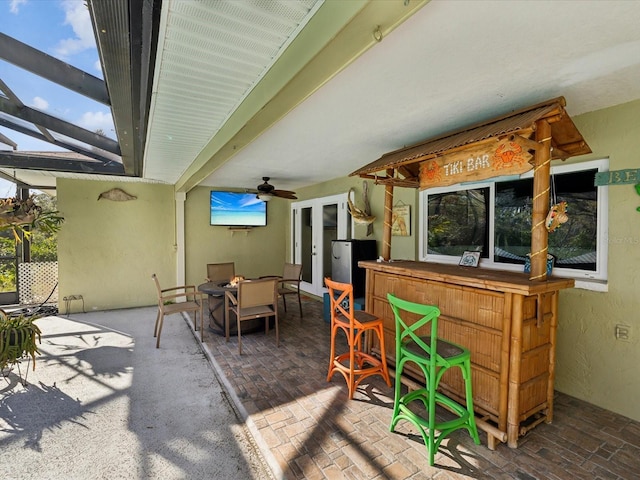 view of patio featuring ceiling fan and an outdoor bar