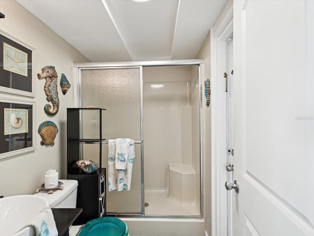 bathroom featuring an enclosed shower and toilet