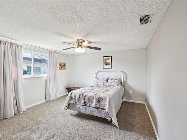 carpeted bedroom featuring ceiling fan and a textured ceiling