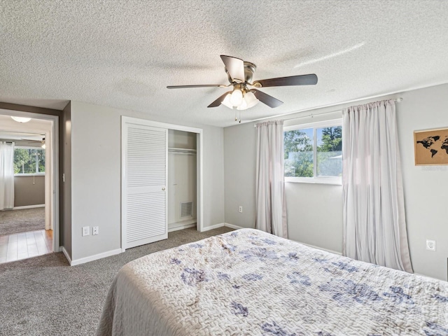 bedroom with multiple windows, carpet, a closet, and ceiling fan