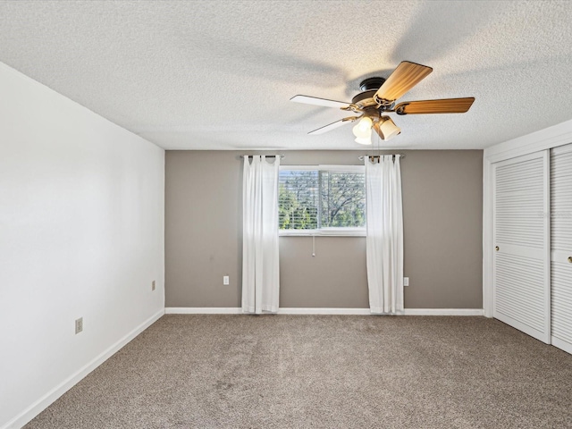 spare room featuring carpet flooring, ceiling fan, and a textured ceiling